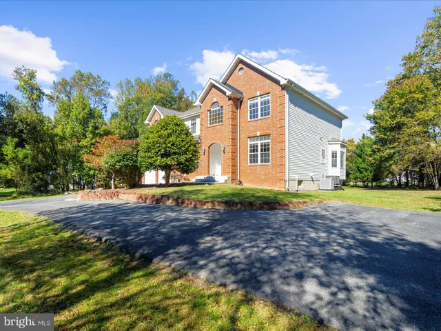 a kitchen with stainless steel appliances kitchen island granite countertop a stove a sink and a wooden cabinets