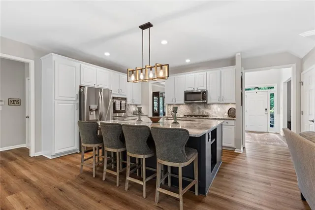 a view of a dining room and livingroom with furniture wooden floor a chandelier