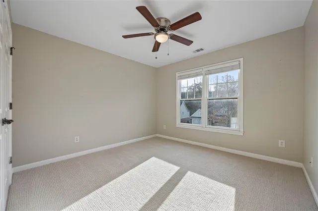an empty room with window and ceiling fan