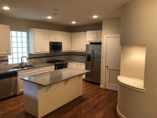 a kitchen with stainless steel appliances granite countertop a stove a sink and a refrigerator