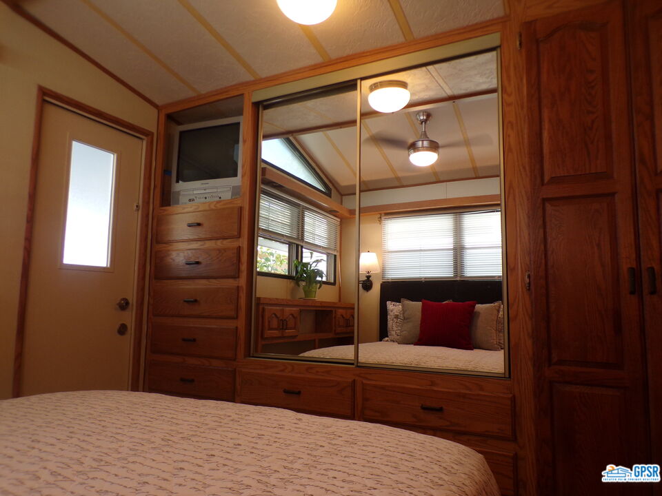 69801 Ramon Road, Unit 246 Cathedral City, CA 92234 - Photo 12 of 44 a bedroom with a bed and a mirror