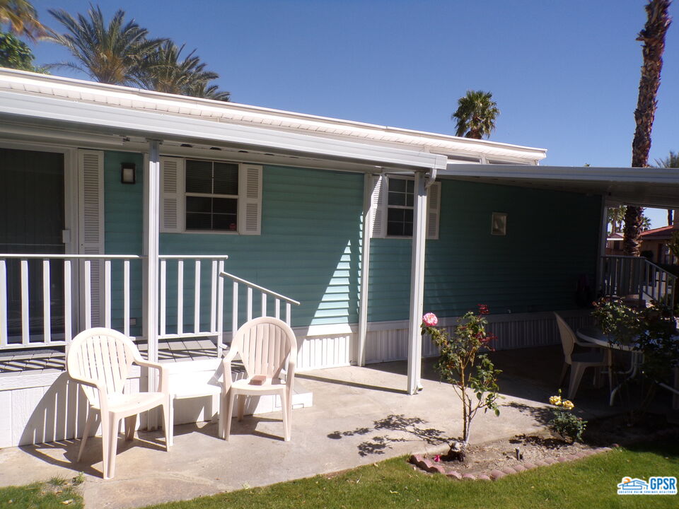 69801 Ramon Road, Unit 246 Cathedral City, CA 92234 - Photo 23 of 44 a view of a patio with table and chairs potted plants and floor to ceiling window