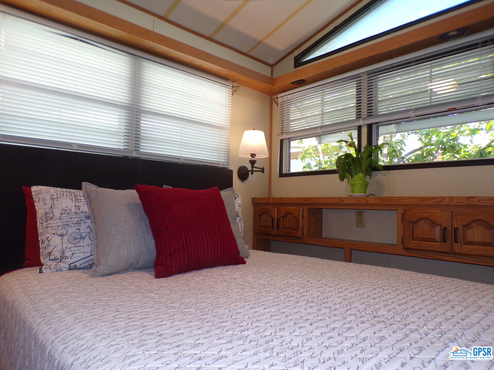69801 Ramon Road, Unit 246 Cathedral City, CA 92234 - Photo 10 of 44 a large bed sitting in a bedroom next to a window
