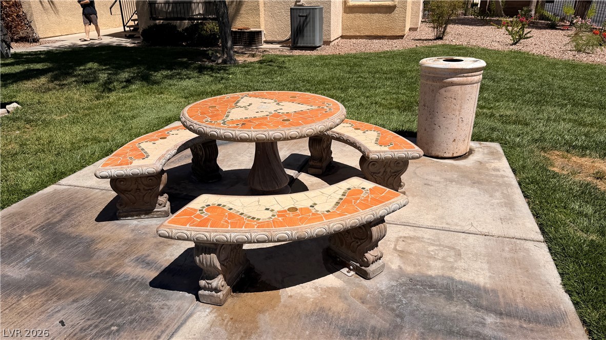 7885 West Flamingo Road, Unit 1131 Las Vegas, NV 89147 - Photo 36 of 36 An inviting mosaic table and benches create an outdoor gathering space on a sunny lawn.