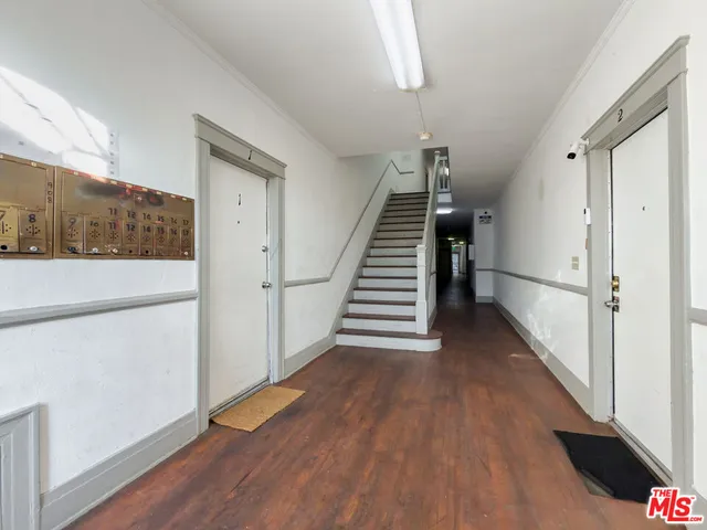a view of a hallway with wooden floor and stairs