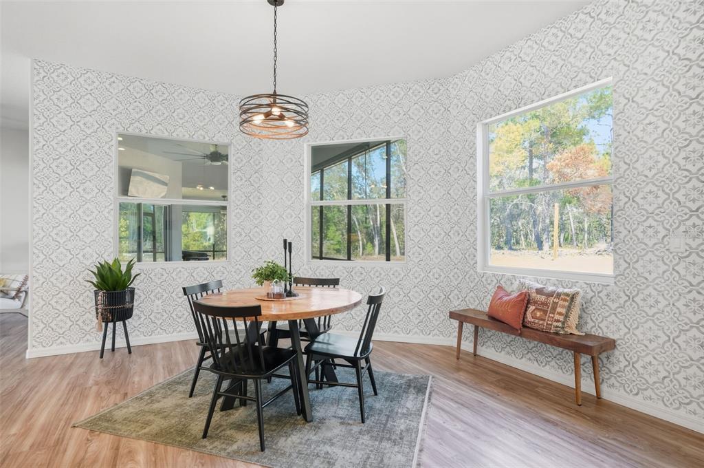 18166 Ramsey Road Weeki Wachee, FL 34614 - Photo 29 of 57 a dining room with furniture potted plants and wooden floor