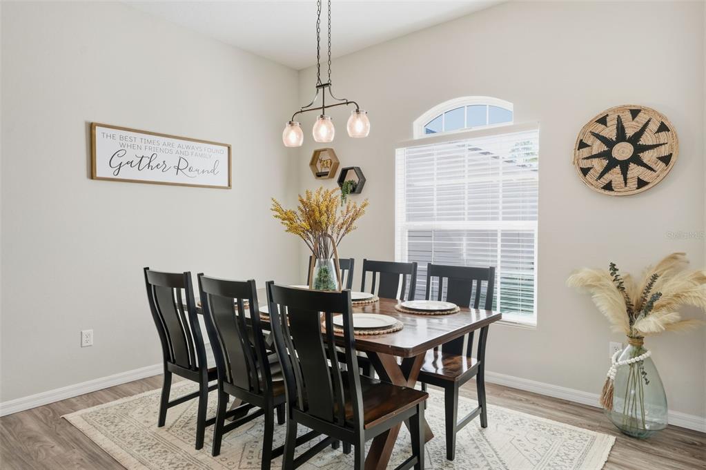 18166 Ramsey Road Weeki Wachee, FL 34614 - Photo 30 of 57 a view of a dining room with furniture wooden floor and a chandelier