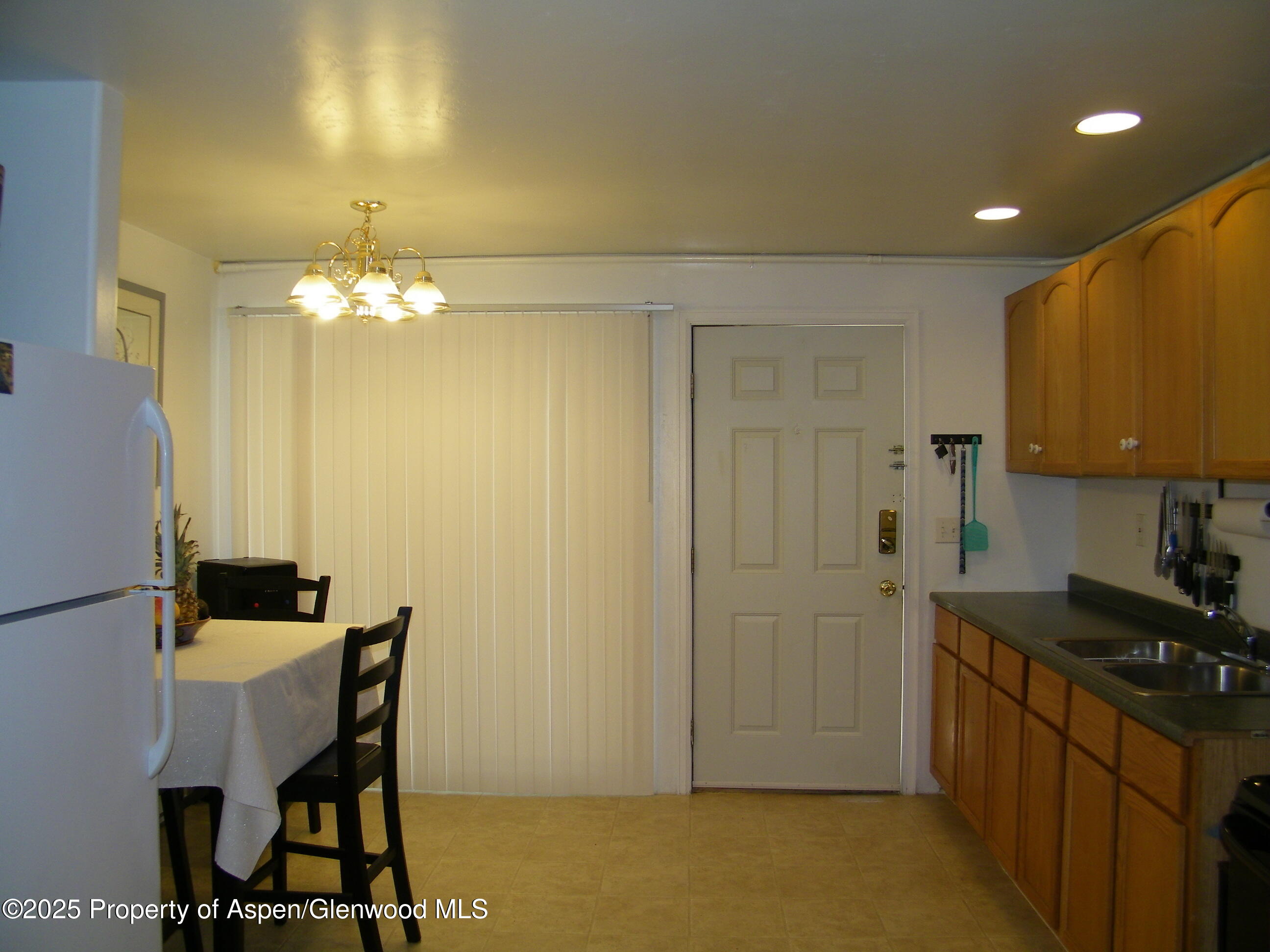 531 Park Avenue Rifle, CO 81650 - Photo 24 of 27 a kitchen with a table chairs and a refrigerator