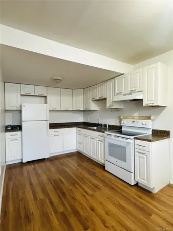 a kitchen with granite countertop white cabinets and white appliances