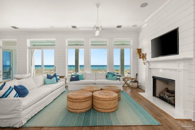 a living room with furniture fireplace and large windows