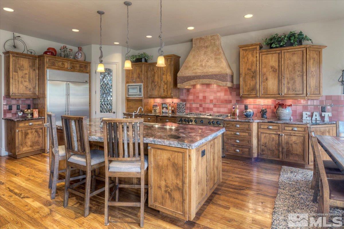 1318 Wolf Run Road Reno, NV 89511 - Photo 9 of 37 a kitchen with stainless steel appliances kitchen island granite countertop a table chairs and a sink