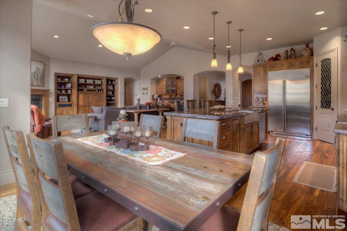 1318 Wolf Run Road Reno, NV 89511 - Photo 10 of 37 a kitchen with stainless steel appliances granite countertop a stove refrigerator a dining table and chairs with wooden floor