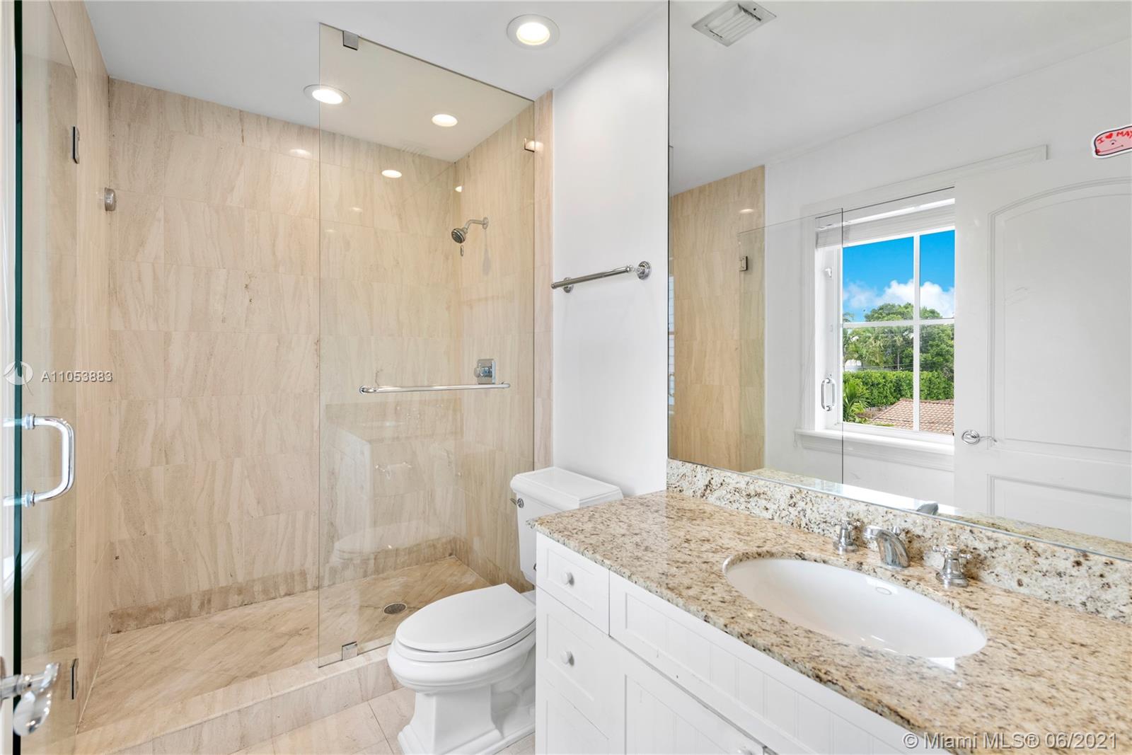 280 Woodcrest Road Key Biscayne, FL 33149 - Photo 28 of 41 a bathroom with a granite countertop sink a toilet a mirror and shower