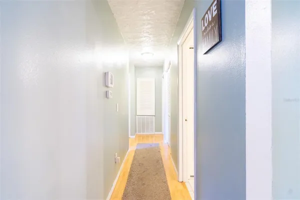 a view of a hallway with wooden floor