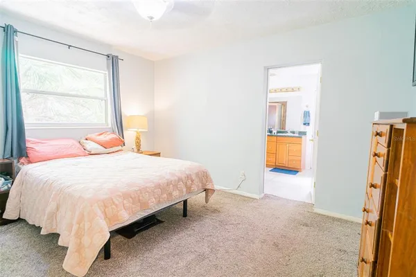 a bedroom with a bed and a flat tv screen on dresser