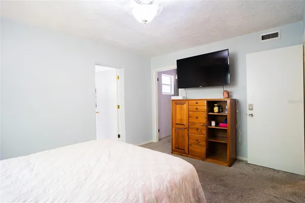 a bedroom with a bed and a flat screen tv