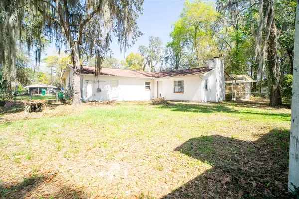 a view of a house with a yard and fence