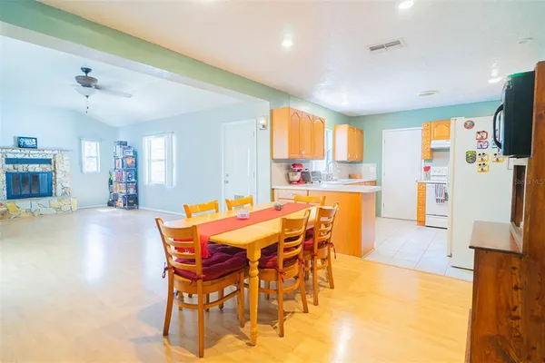 a dining room with stainless steel appliances a table and chairs