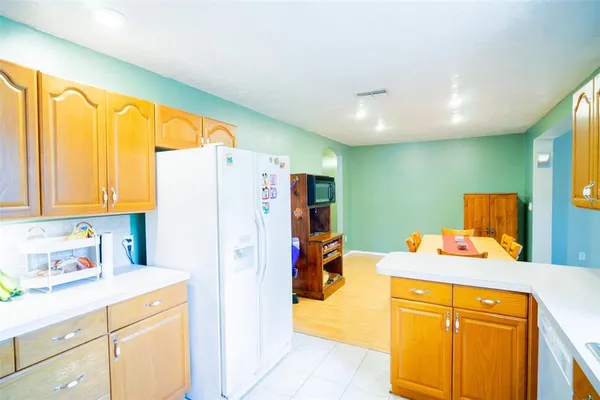 a bedroom with a bed and a refrigerator