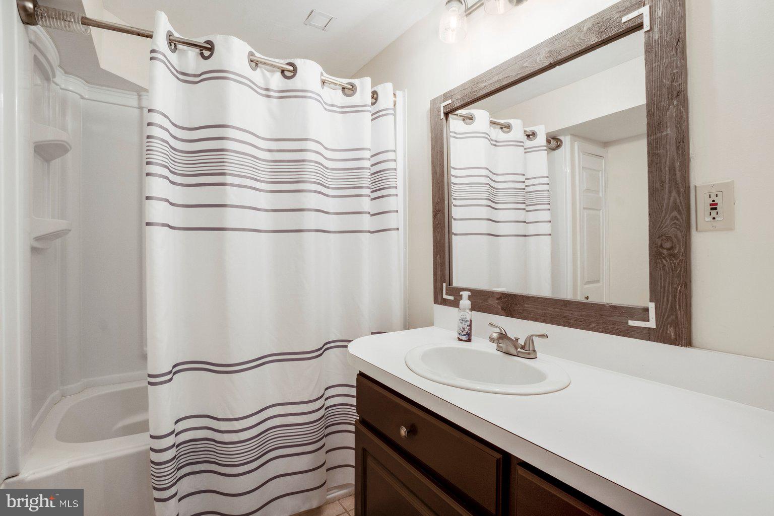 1617 Cape May Road Baltimore, MD 21221 - Photo 36 of 37 a bathroom with a sink a mirror and a shower