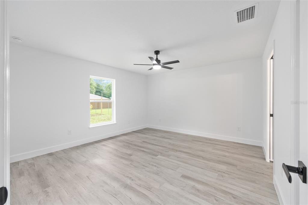 6052 Northwest 53rd Street Road Ocala, FL 34482 - Photo 18 of 26 wooden floor in an empty room with a window