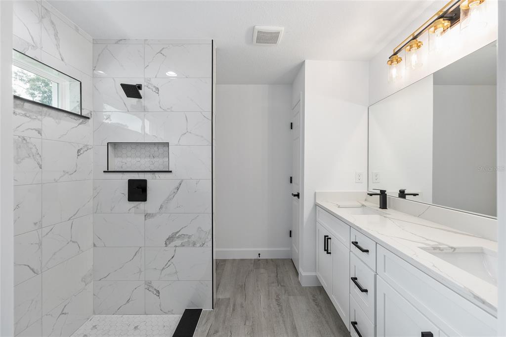 6052 Northwest 53rd Street Road Ocala, FL 34482 - Photo 19 of 26 a bathroom with a double vanity sink a toilet and shower