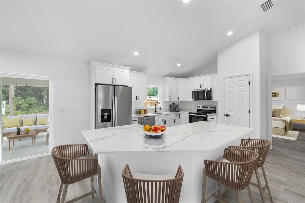 6052 Northwest 53rd Street Road Ocala, FL 34482 - Photo 3 of 26 a kitchen with stainless steel appliances granite countertop a dining table and chairs
