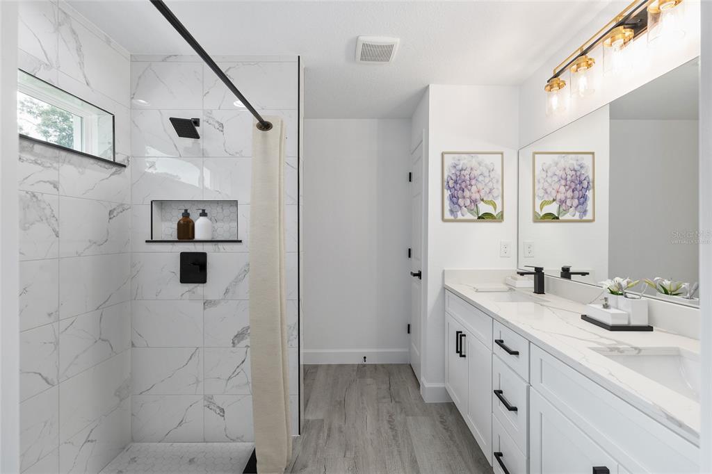 6052 Northwest 53rd Street Road Ocala, FL 34482 - Photo 6 of 26 a bathroom with a double vanity sink mirror and shower