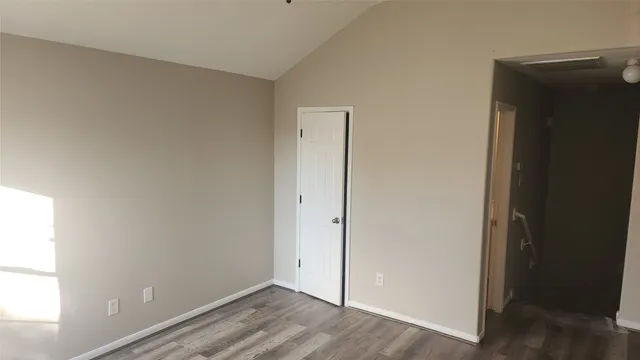 an empty room with wooden floor and closet