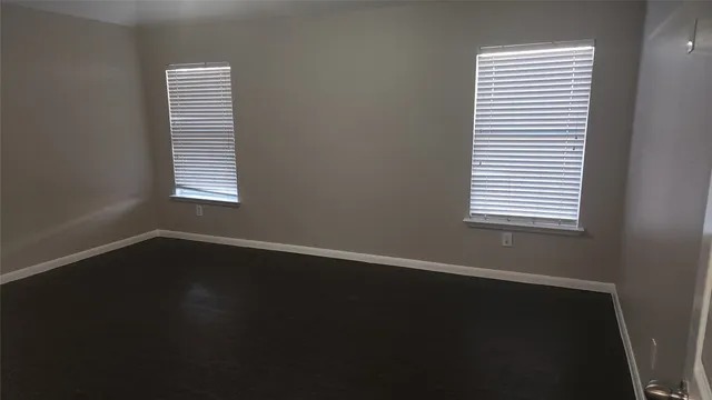 an empty room with wooden floor and a window