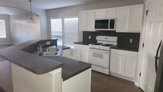 a kitchen with white cabinets and white appliances