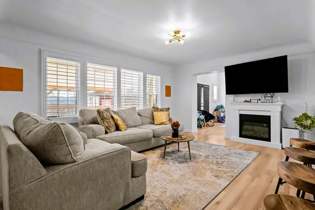 a kitchen with stainless steel appliances kitchen island granite countertop a sink dishwasher a stove a refrigerator a microwave oven with cabinets and wooden floor