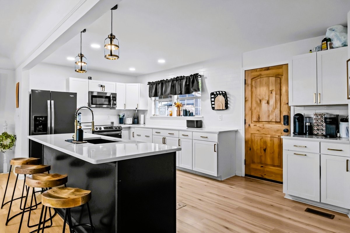 1975 Kelly Road Holladay, TN 38341 - Photo 15 of 88 a kitchen with stainless steel appliances kitchen island granite countertop a sink dishwasher a stove a refrigerator a microwave oven with cabinets and wooden floor