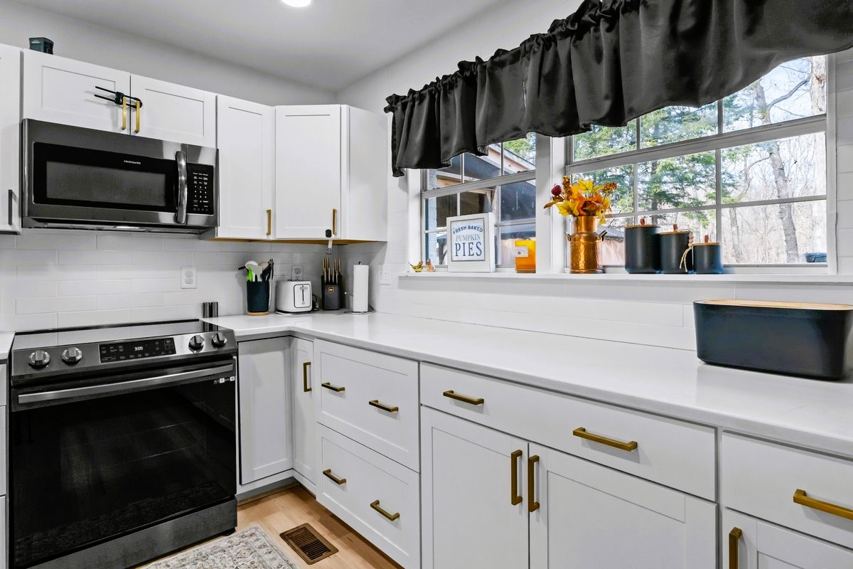 1975 Kelly Road Holladay, TN 38341 - Photo 16 of 88 a kitchen with stainless steel appliances a stove microwave and cabinets