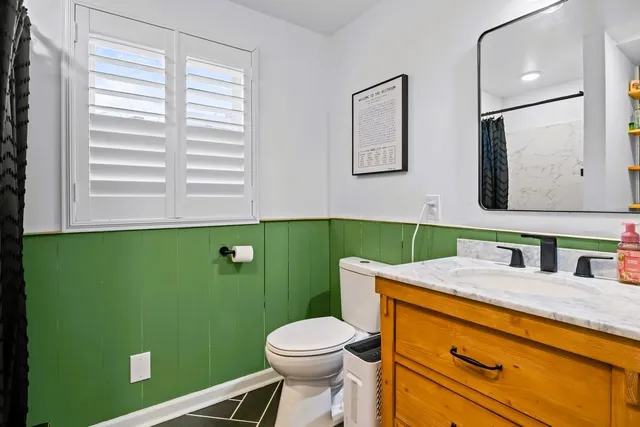 a bathroom with a sink mirror and toilet
