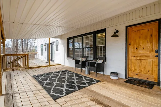 a kitchen with stainless steel appliances a dining table chairs refrigerator and sink