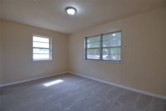 a view of an empty room with wooden floor and closet