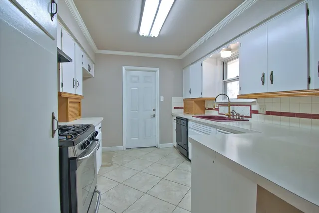 a kitchen with cabinets appliances a sink and a window