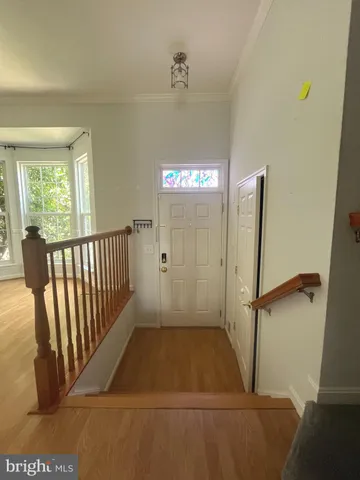 a view of a hallway with wooden floor and stairs