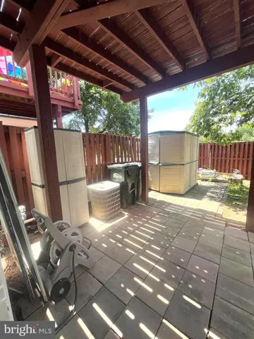 a view of a patio with table and chairs potted plants with wooden floor and fence