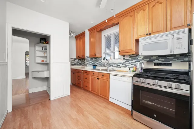 a white kitchen with stainless steel appliances a refrigerator and a stove