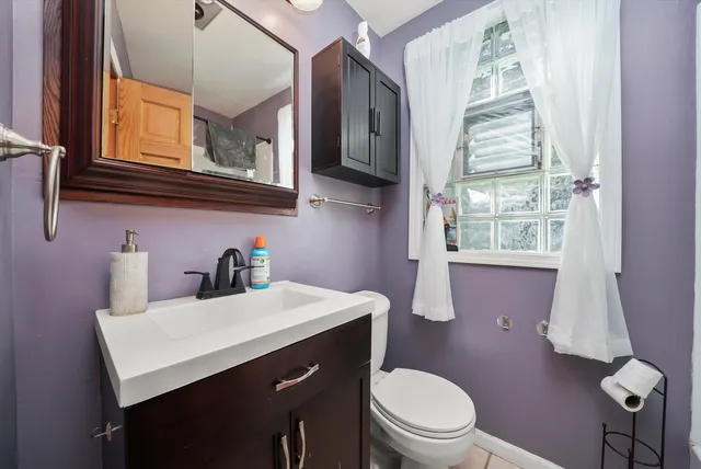 a bathroom with a sink mirror vanity and toilet