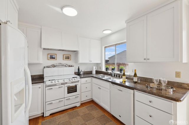 a kitchen with white cabinets and white appliances