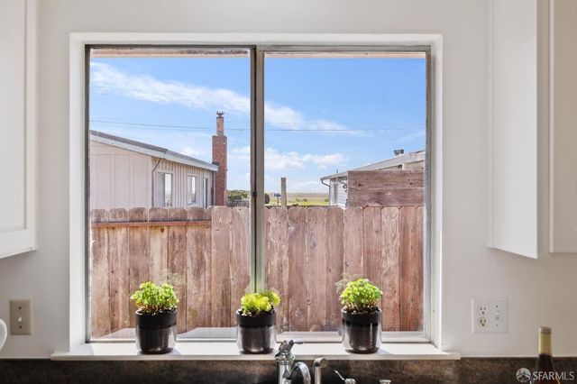 a vase of flowers sitting on a table with window