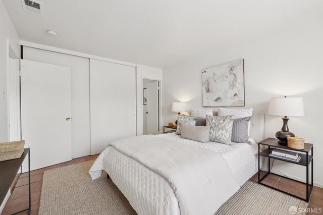 a bedroom with a bed and a lamp on the dresser