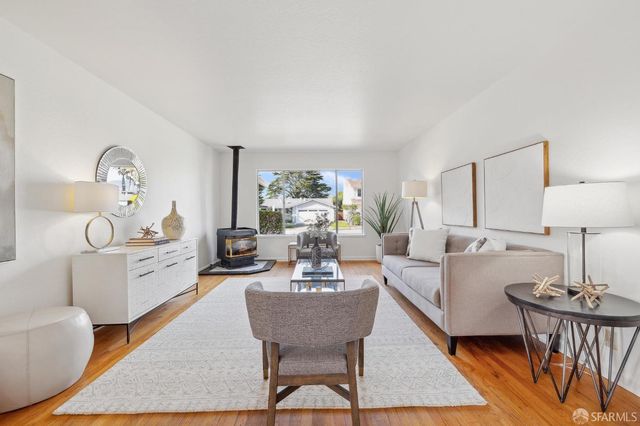 a living room with furniture a rug a lamp and a table