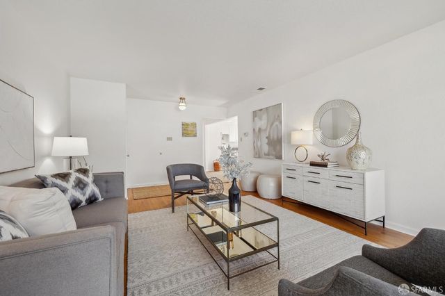 a living room with furniture a rug and a clock
