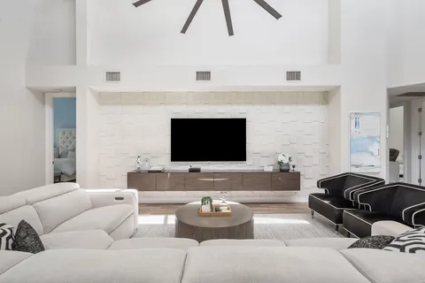 a large kitchen with a large island in the center a sink a dining table and chairs