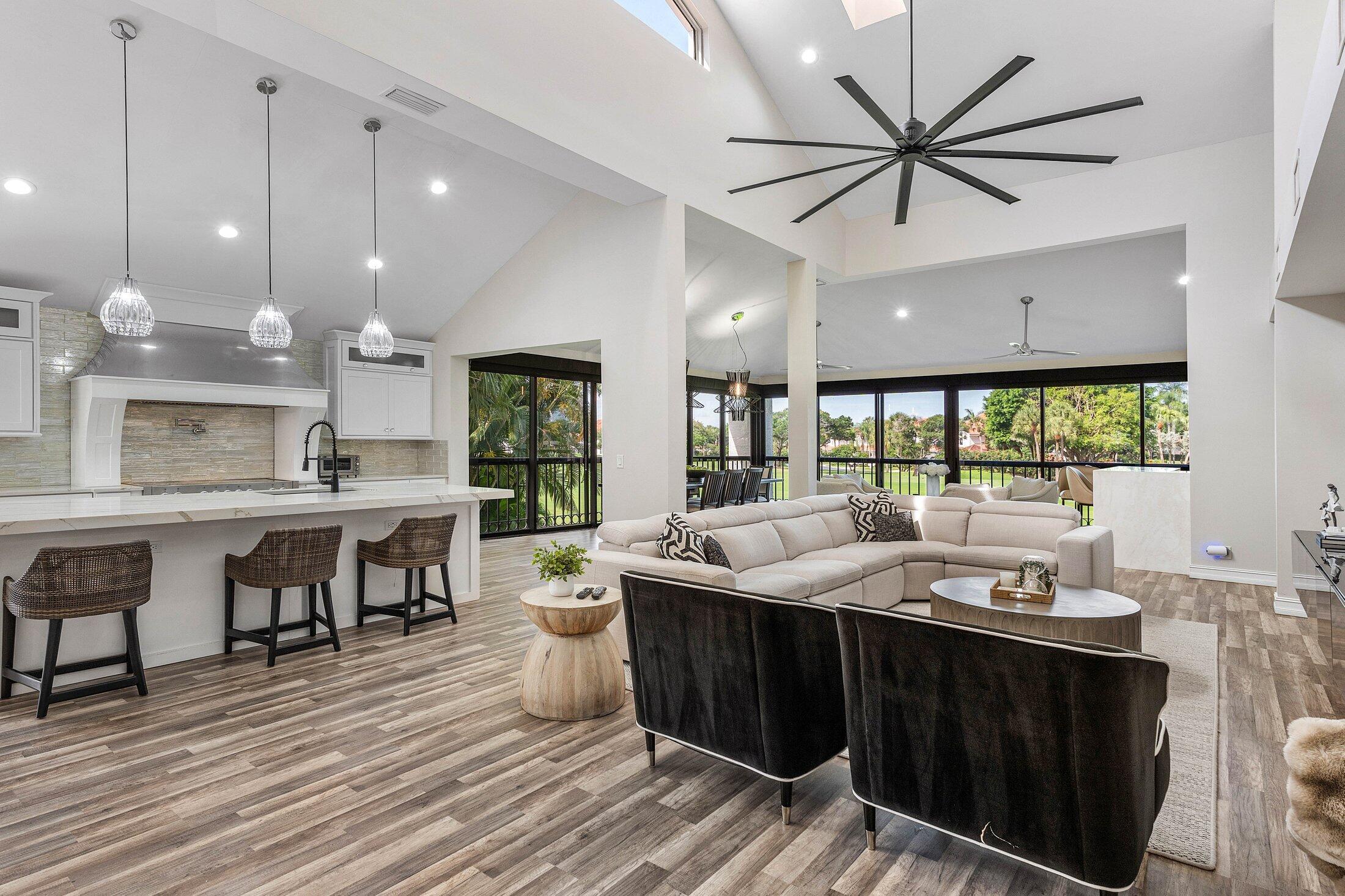 5887 Northwest 24th Avenue, Unit 1203 Boca Raton, FL 33496 - Photo 13 of 62 a large kitchen with a large island in the center a sink a dining table and chairs
