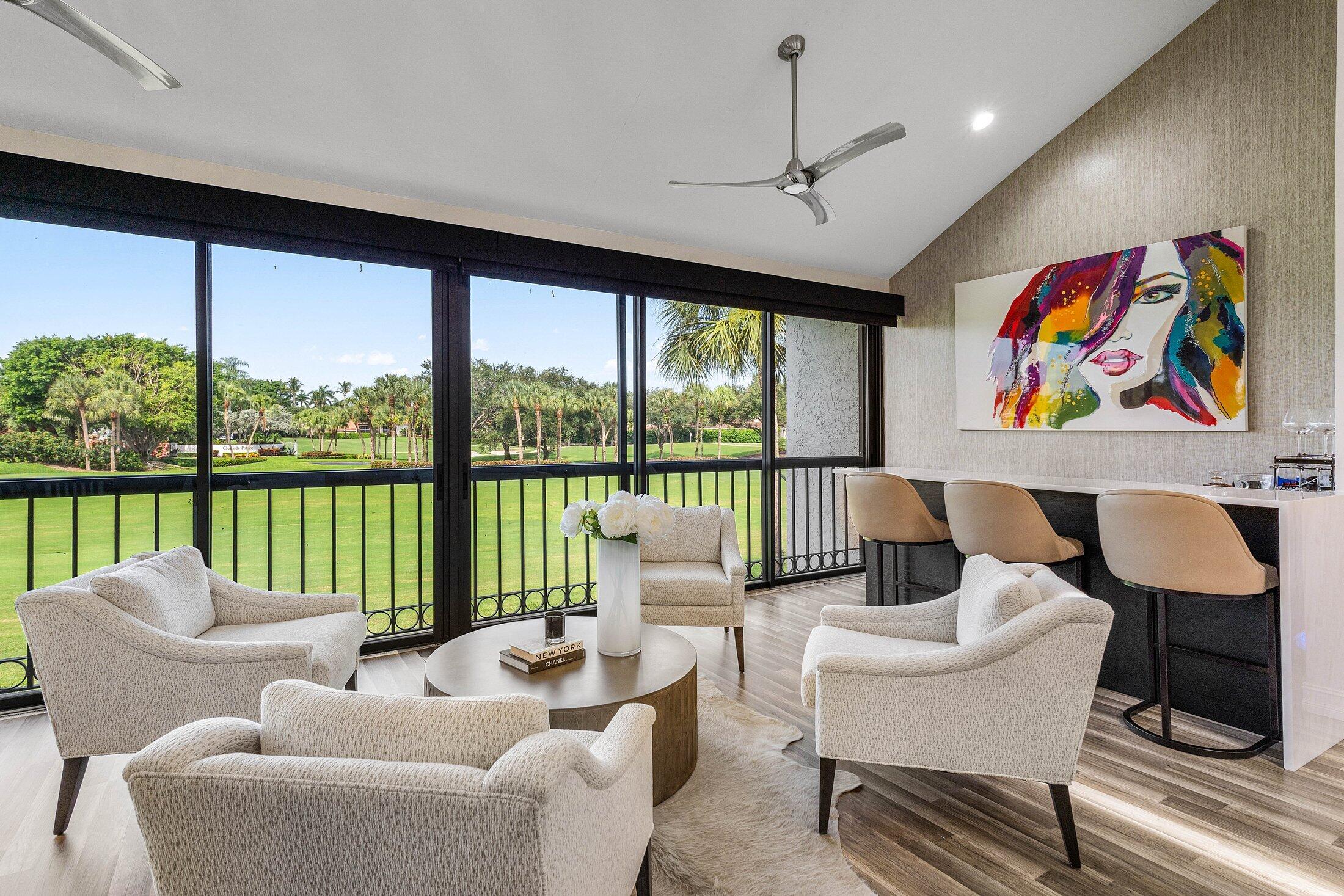 5887 Northwest 24th Avenue, Unit 1203 Boca Raton, FL 33496 - Photo 31 of 62 a living room with furniture a floor to ceiling window and a flat screen tv